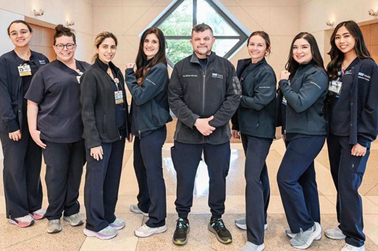 Group of certified nurses and staff posing together in a well-lit indoor setting.