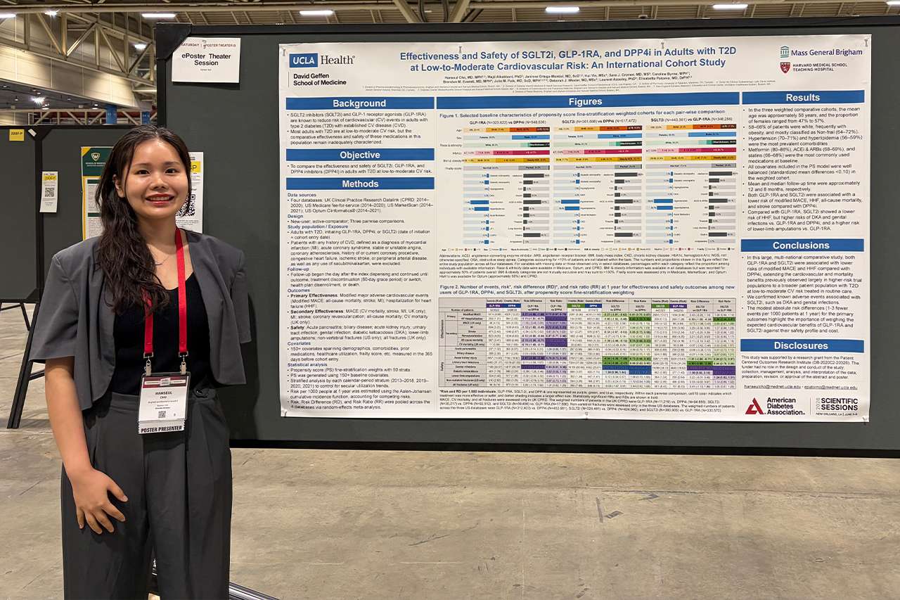 Presenter standing beside large research poster at a conference.