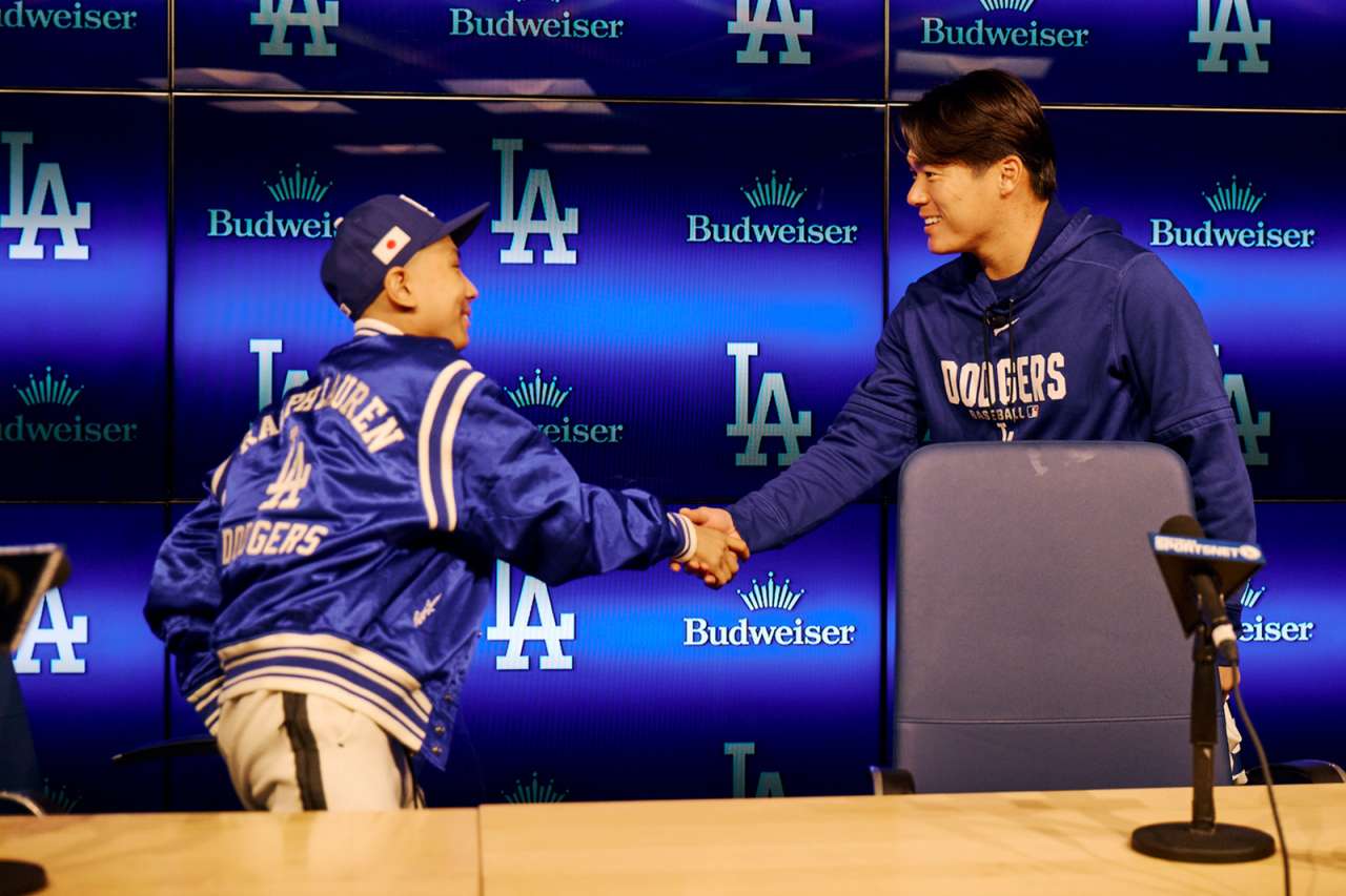 A teen oncology patient shakes hands with a Dodgers pitcher.