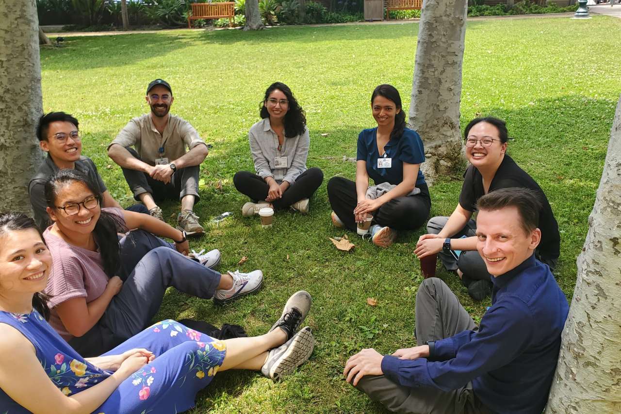 Eight palliative Fellows Group sitting in a circle on the park.