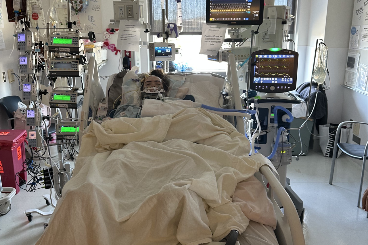 A patient in a hospital room is connected to a lot of monitors.