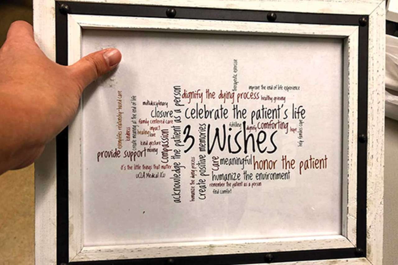 Person holding frame displaying 3 Wishes terminology