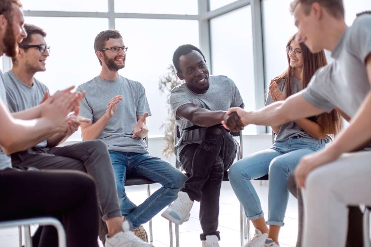 A support Group Circle with Two Men Shaking Hands