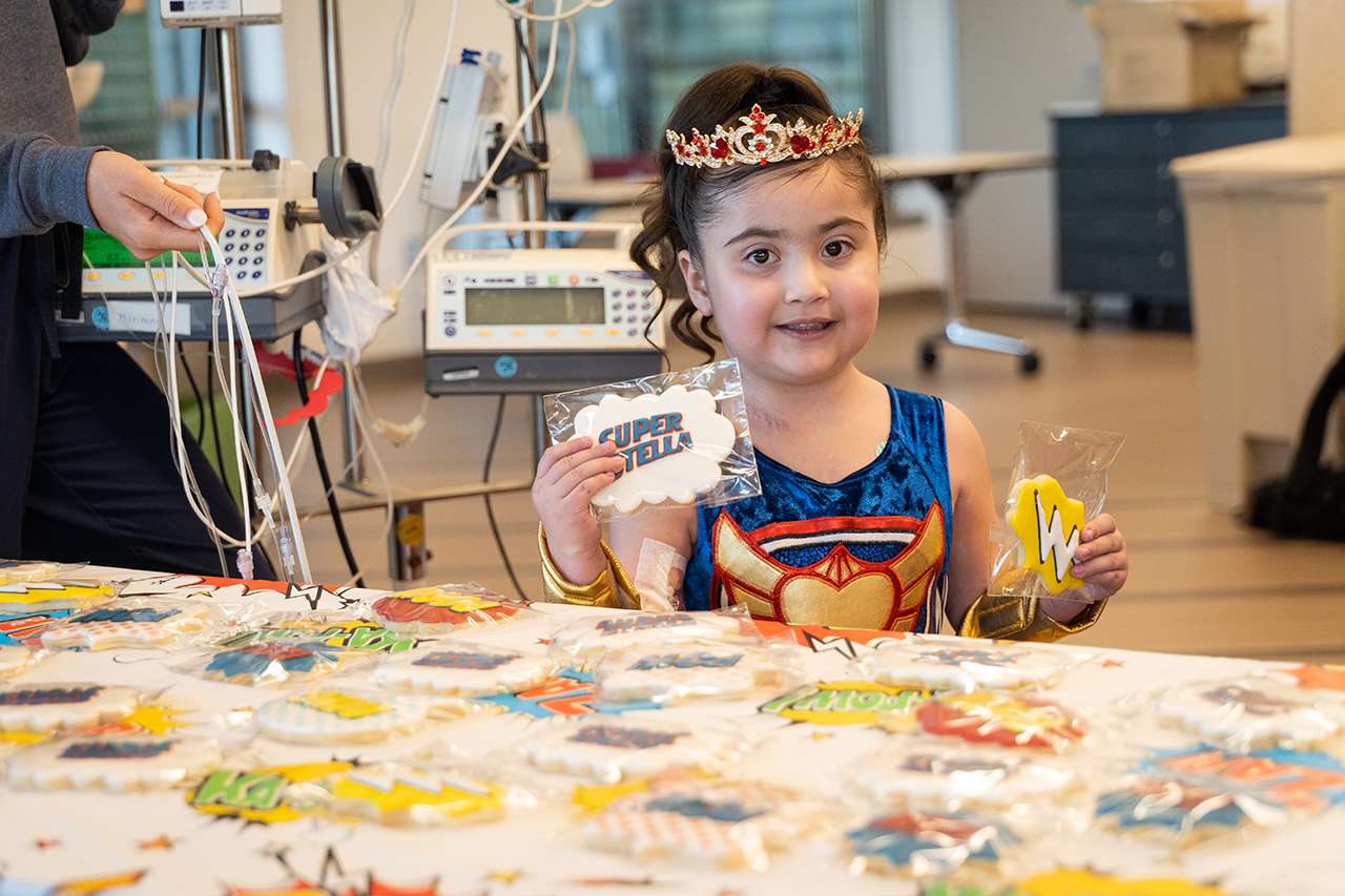Pediatric Patient, Stella, enjoys custom-made goodies at her surprise superhero party.