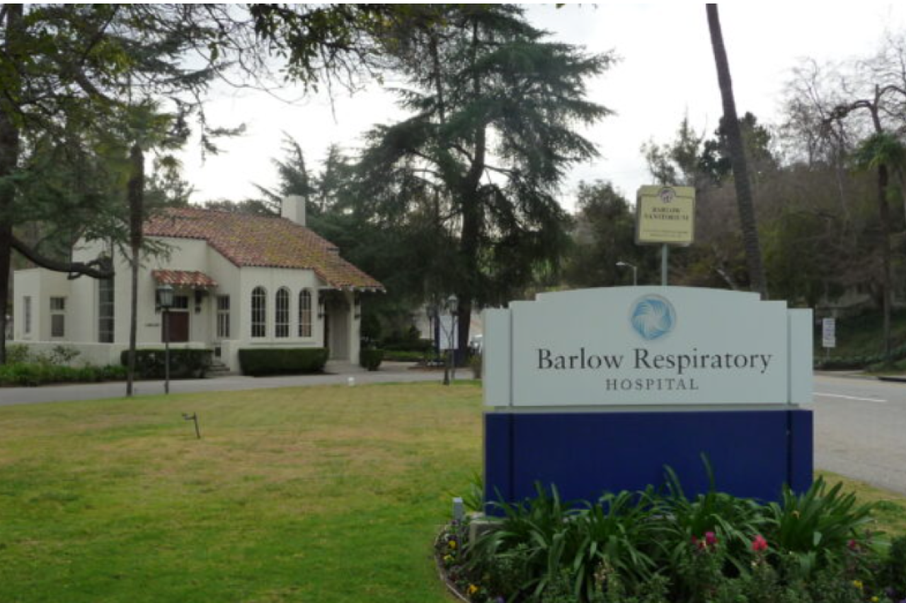 Barlow Respiratory sign on lawn with white building and trees behind