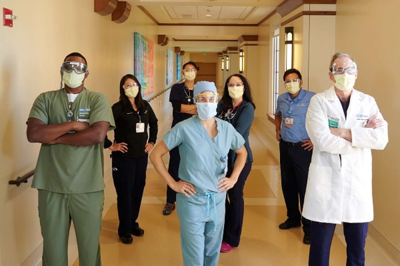 UCLA Health faculty and staff stand in a hospital hallway.