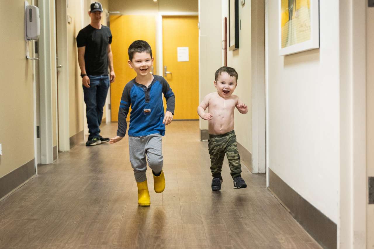 Liam and his brother run in the hospital halls as dad looks on.