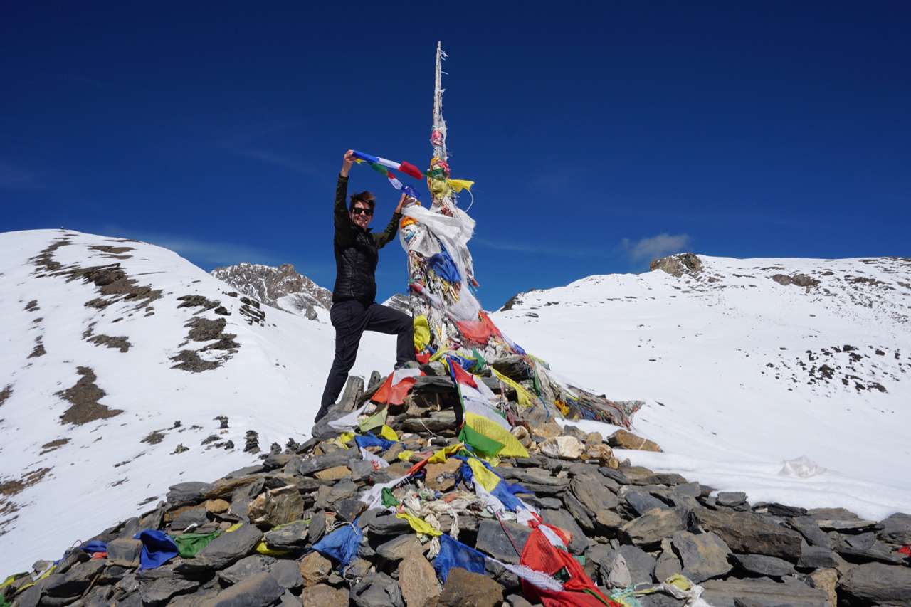 Lindsay Brant hangs a prayer flag at snow-capped Numa La Pass