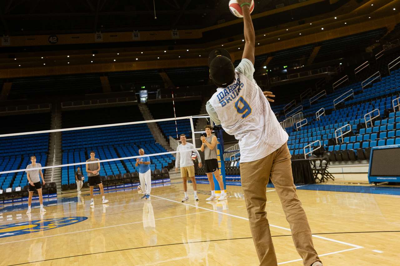 Samuel Idahosa hits a volleyball on the court.