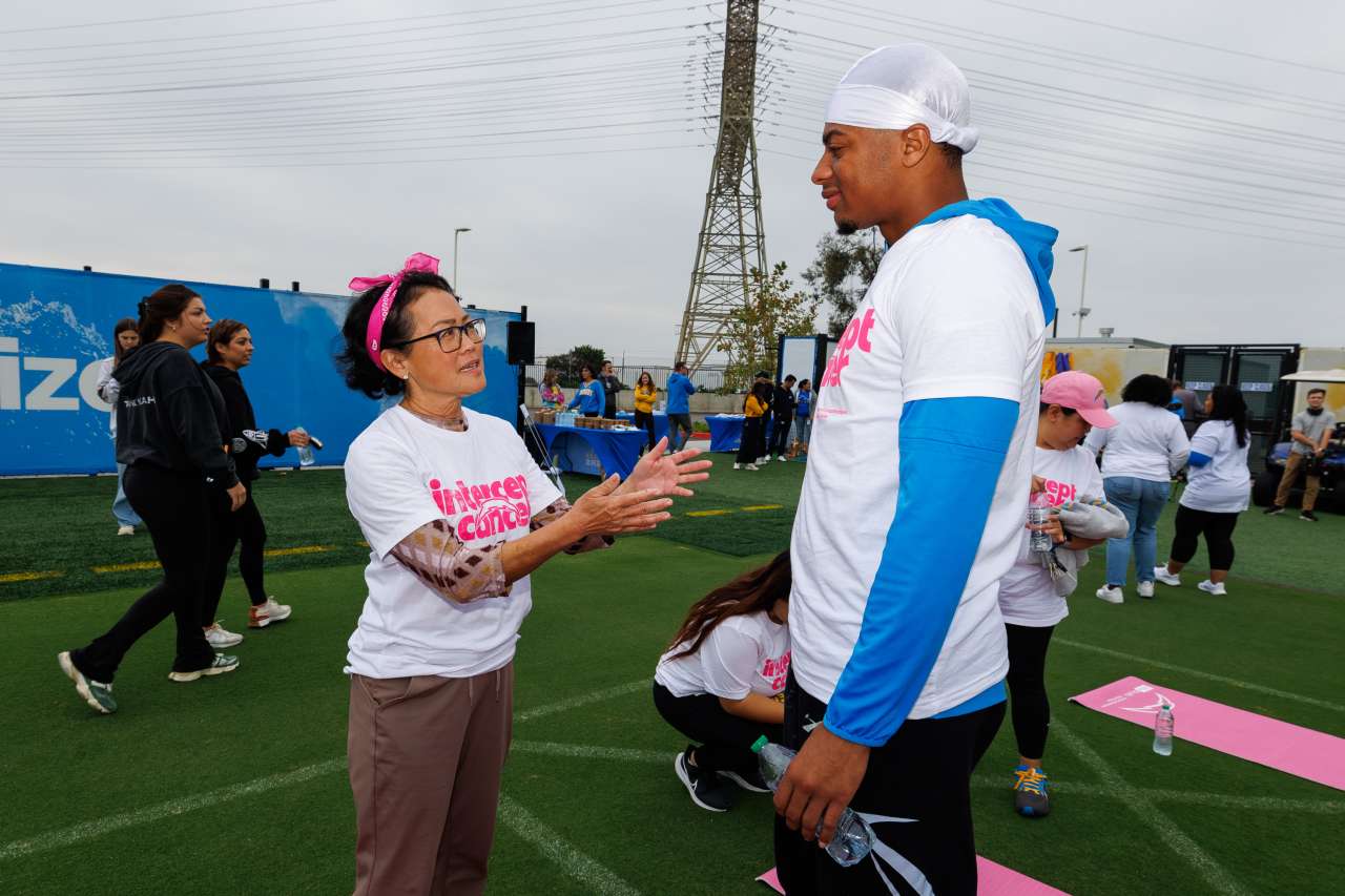 Cancer survivor Tricia Takasugi speaks with Chargers wide receiver Brenden Rice