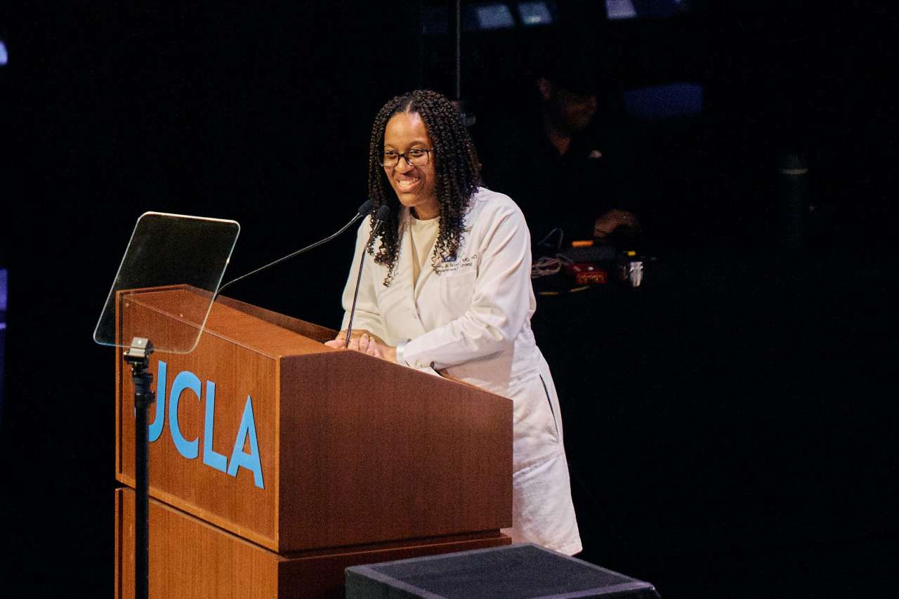 Dr. Kymora Scotland smiles as she stands behind a podium at the UCLA White Coat Ceremony.