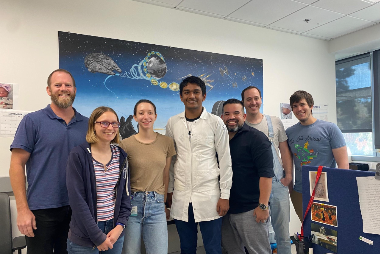 The Vondriska Lab team poses for a group photo in front of a space-themed mural.