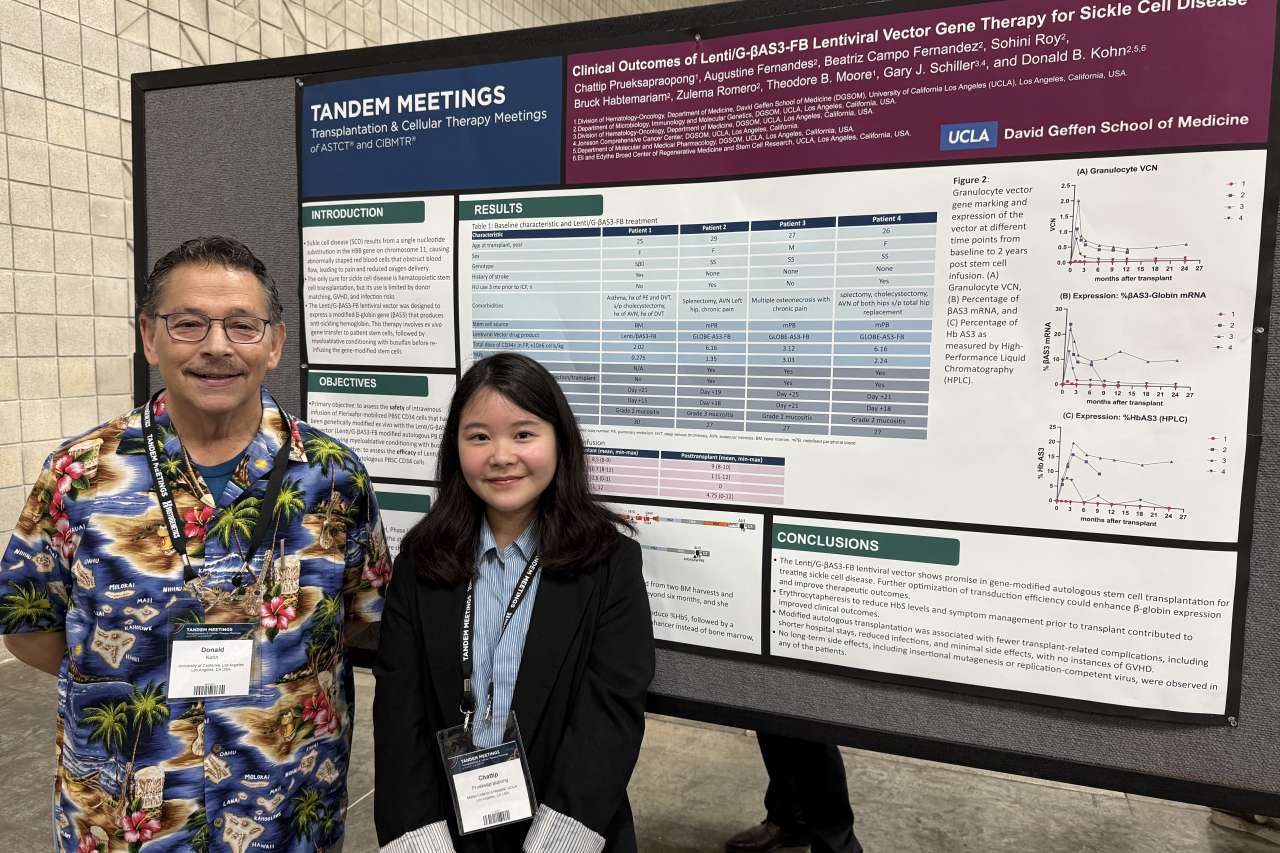 Two presenters standing before a research poster at an academic conference