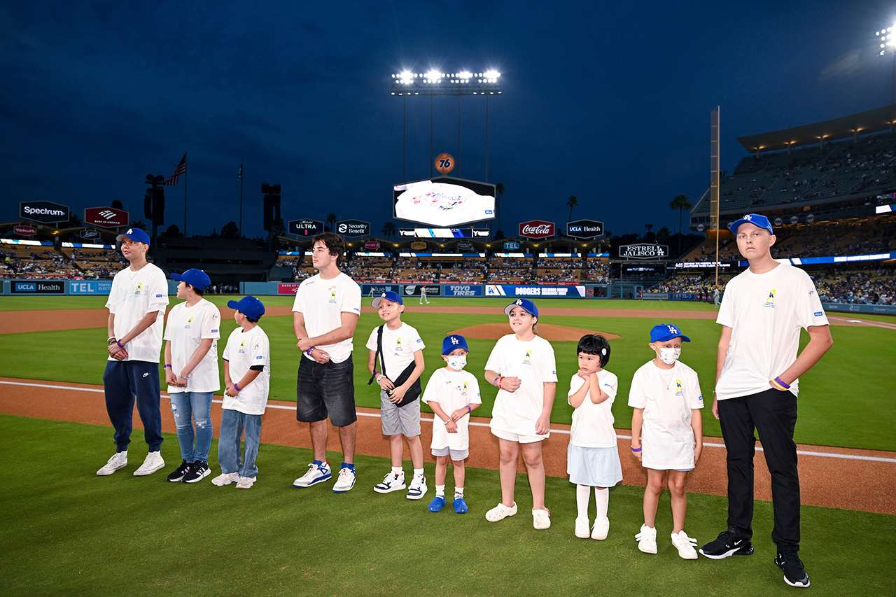 Pediatric cancer patients and survivors line up on the field at Dodger Stadium