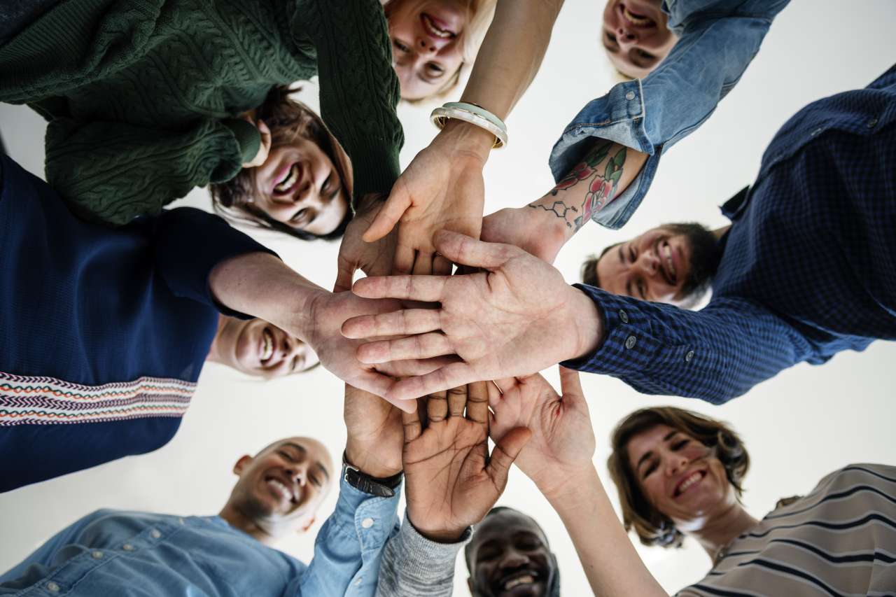 Diverse group of cancer patients holding hands in a circle