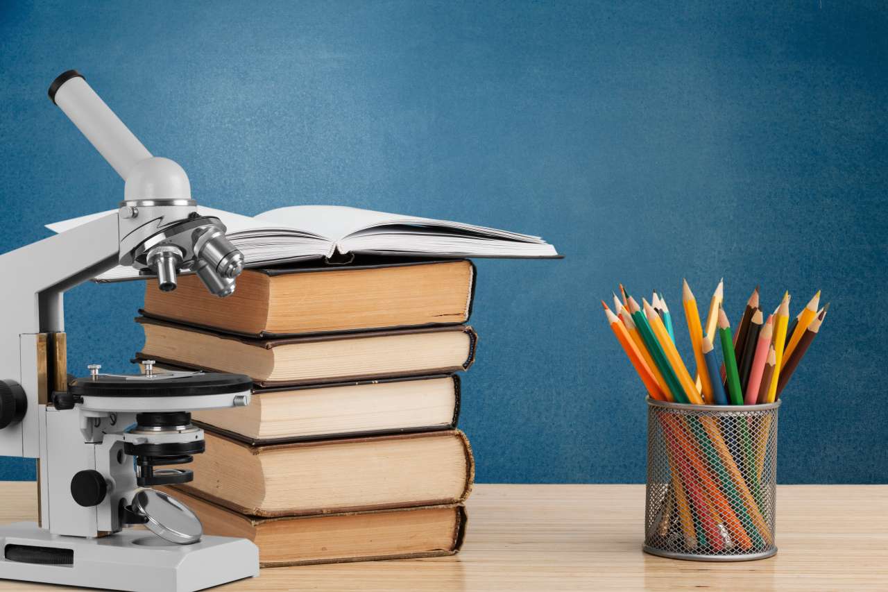 Microscope next to a stack of research books