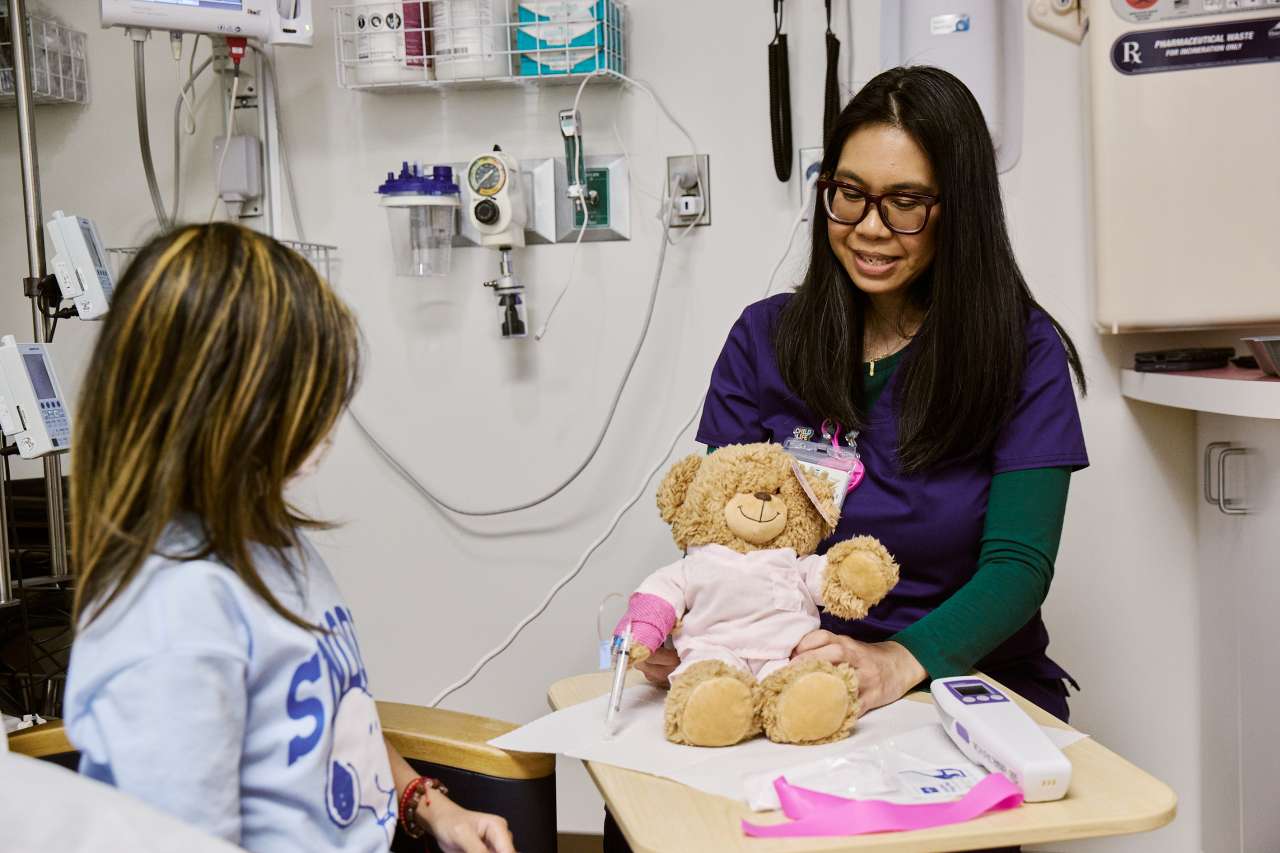 A Child Life Specialist visits with a patient.