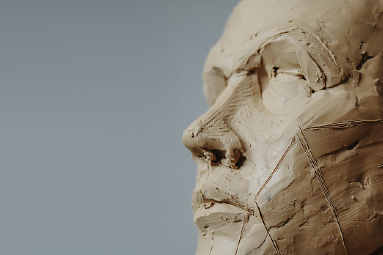 a man's face sculpted from clay