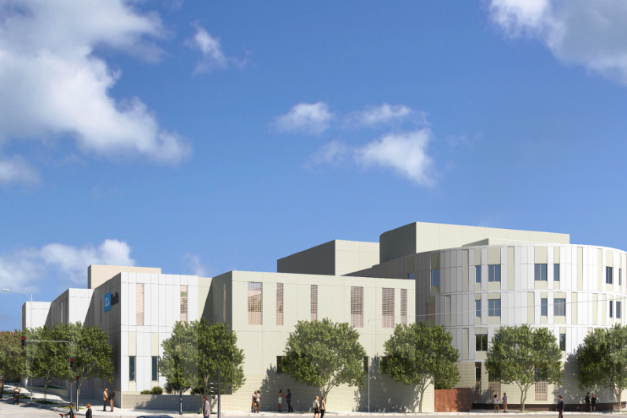 Modern light-colored multi-story building with trees and a blue sky