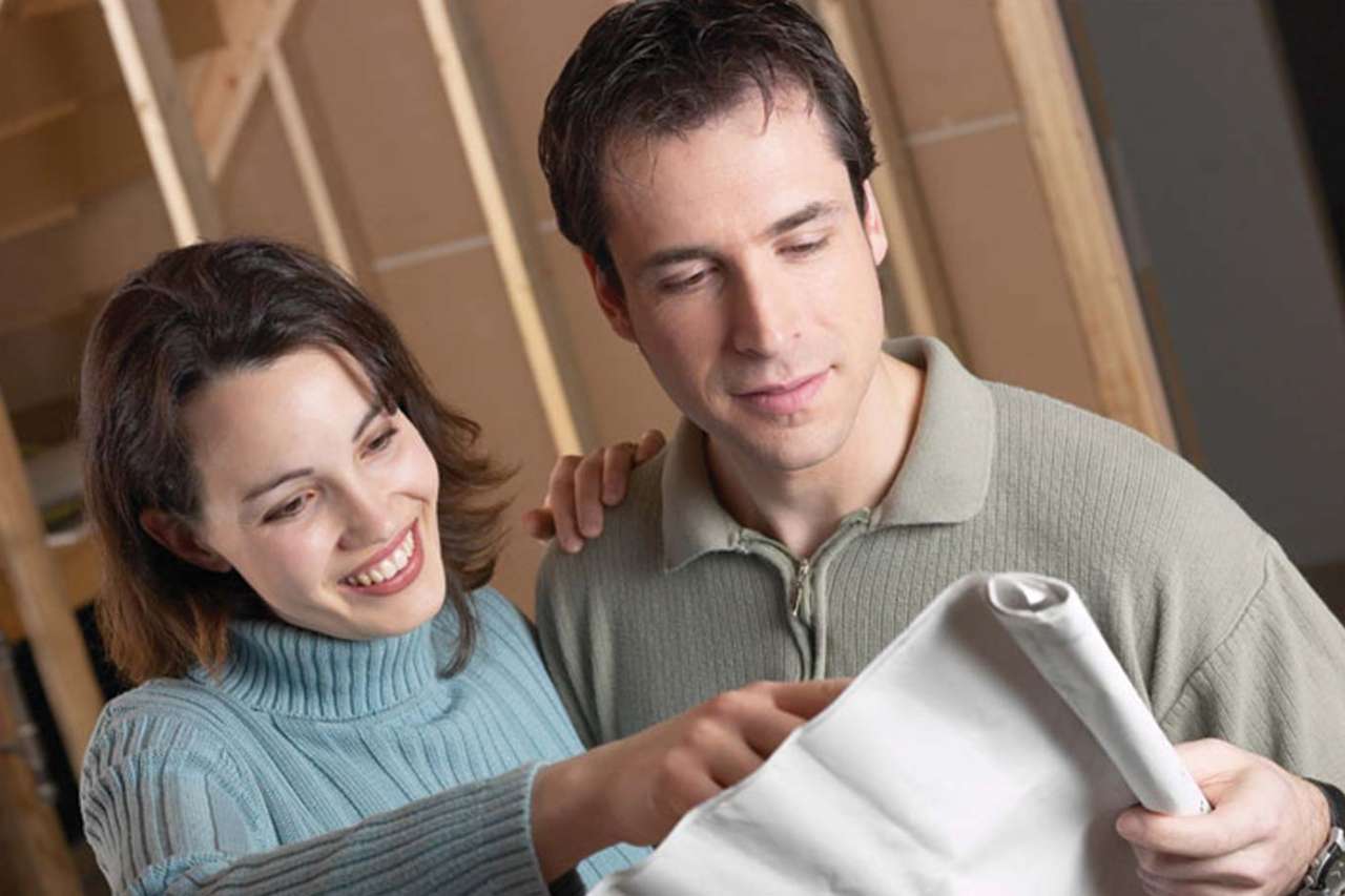 Couple holding up planning document