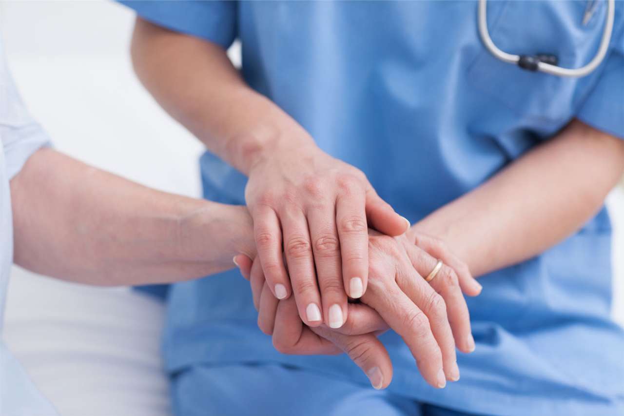Physician holding patient hand