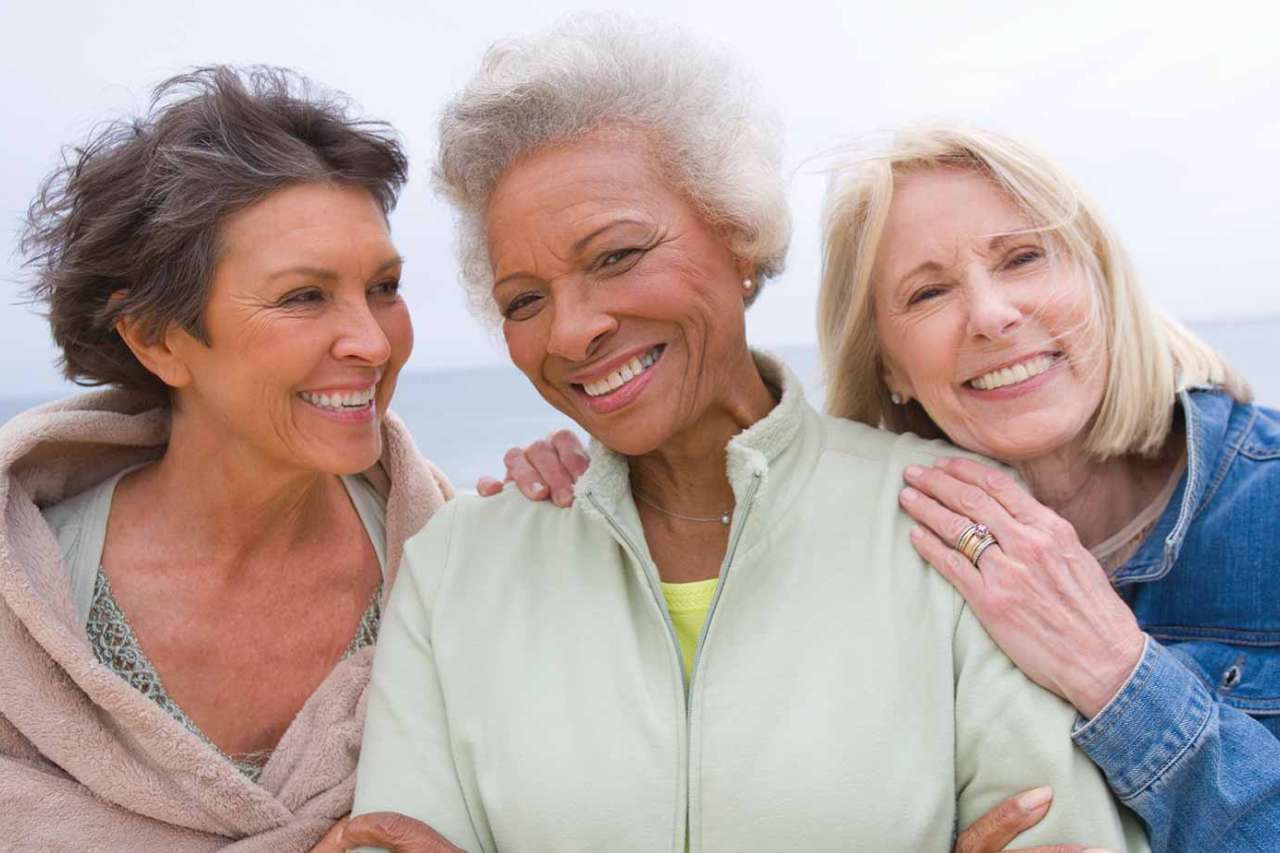 Three woman huddled together and smiling
