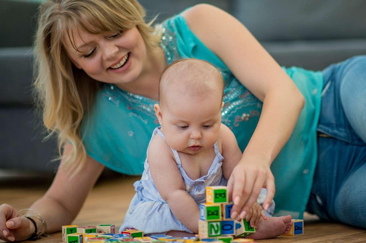 Mother and infant playing with toy blocks