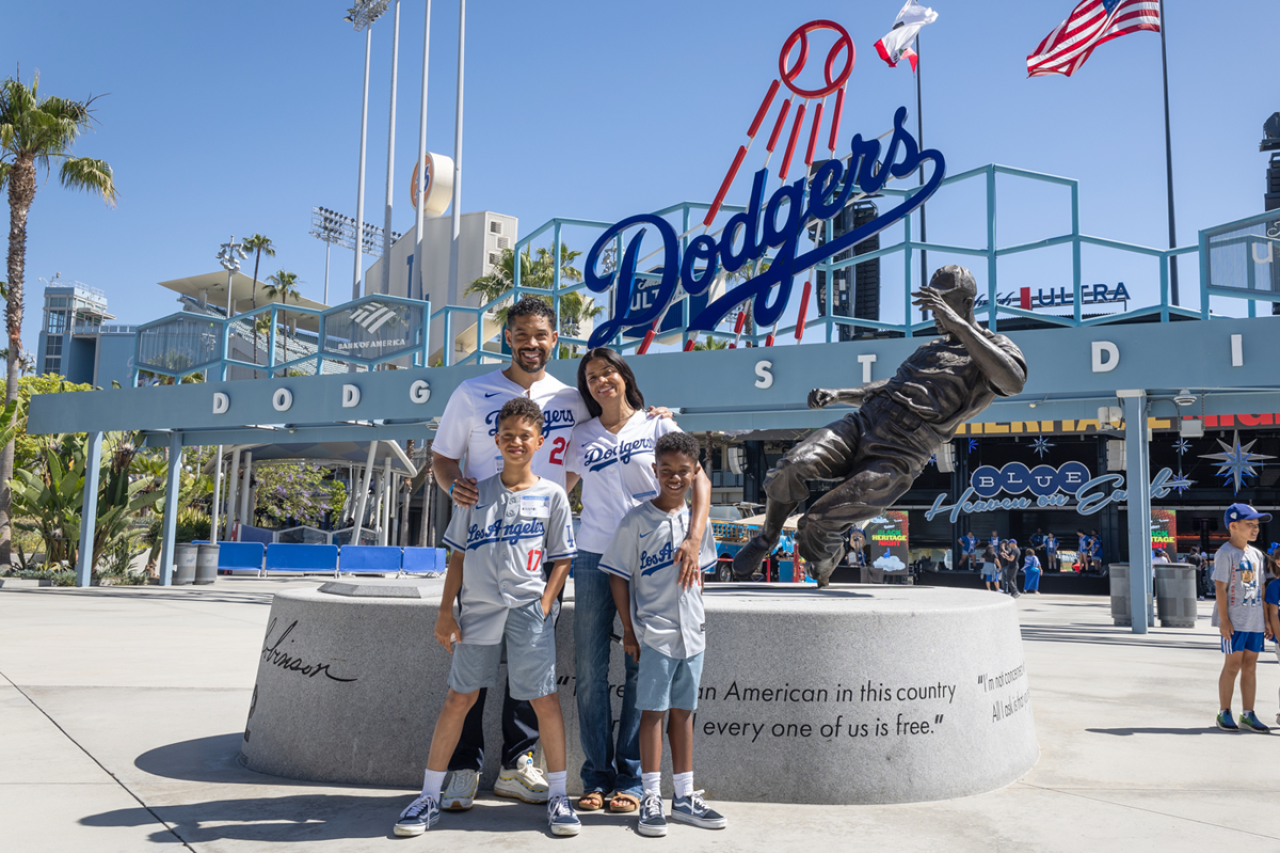 Kristofer Jones with family in front of Dodger Stadium with a statue in the background.