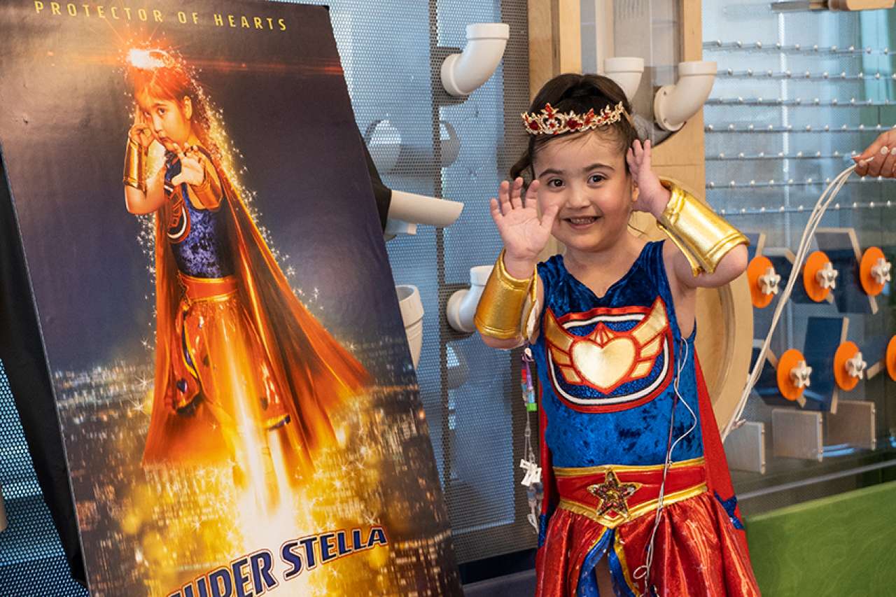 Pediatric Patient, Stella unveils her customized movie poster at her surprise superhero party