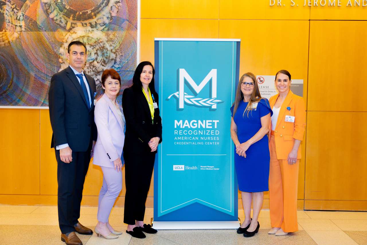 UCLA Health leaders stand beside a Magnet® poster.