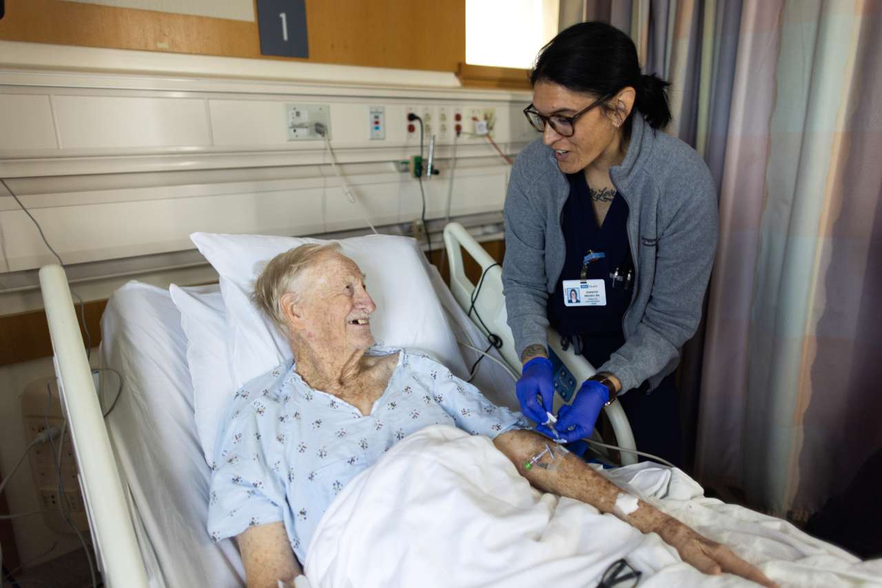 A nurse visits with a patient.