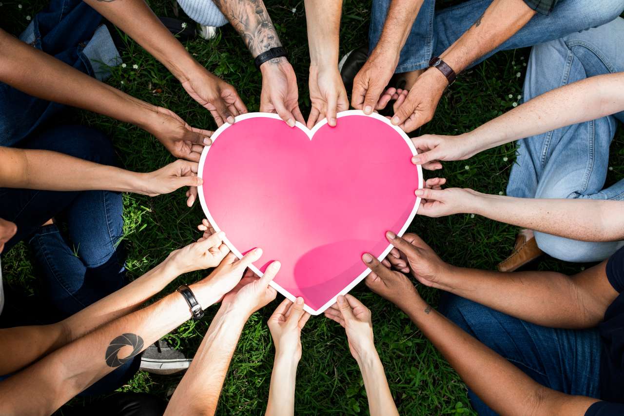 People in a circle holding a heart