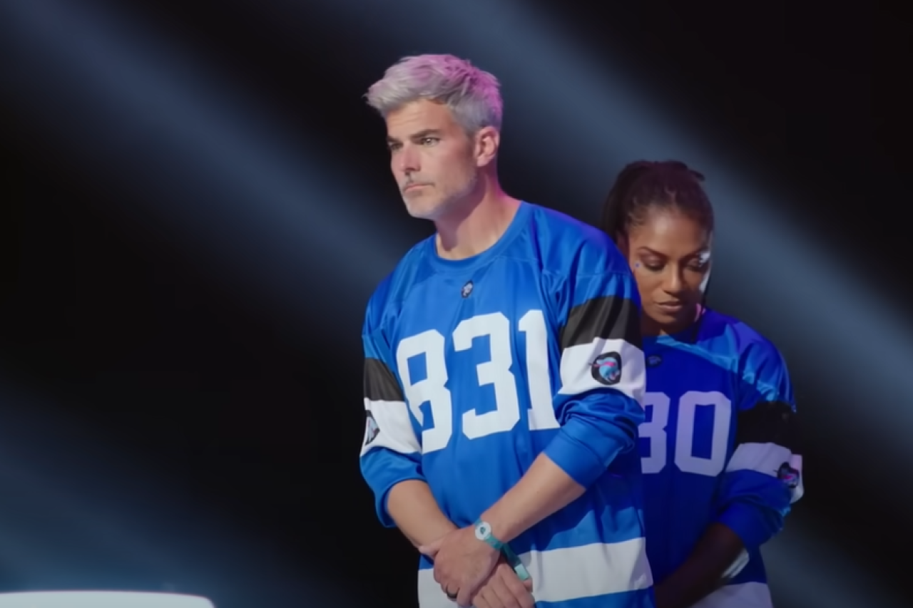 Jeffrey Randall Allen stands in a blue jersey labeled 831 during a tense moment on Beast Games, the Amazon Prime Video competition hosted by MrBeast