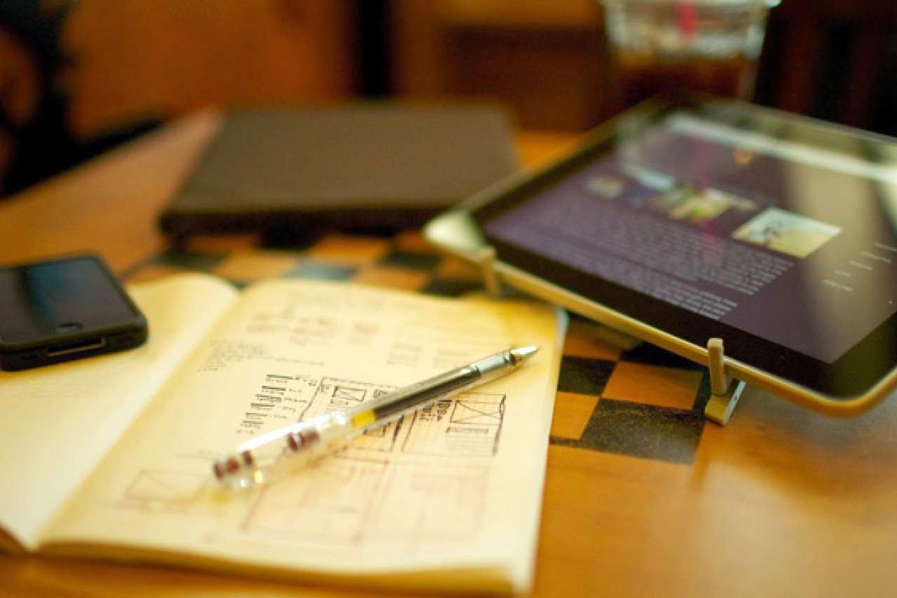 Phone and iPad with a notebook and pen