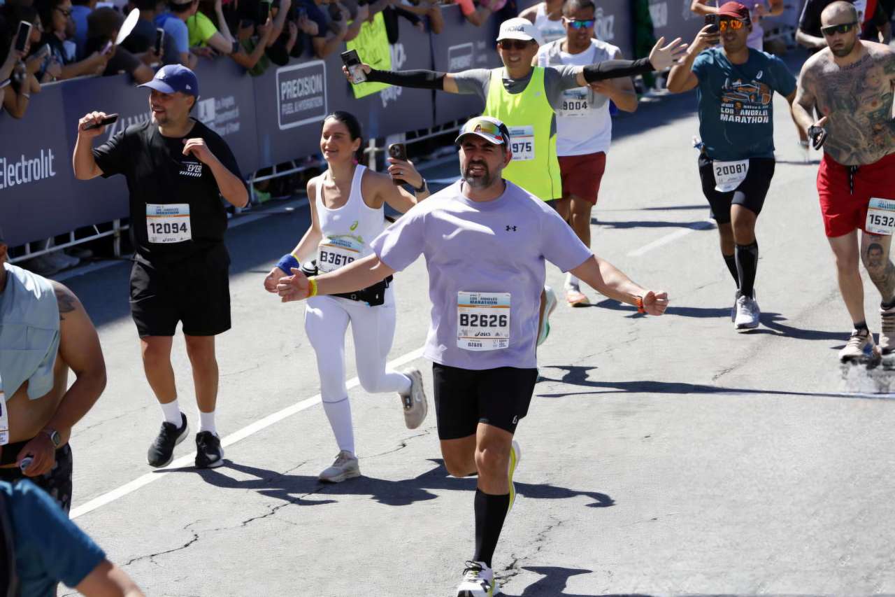 Man finishing marathon race among other runners