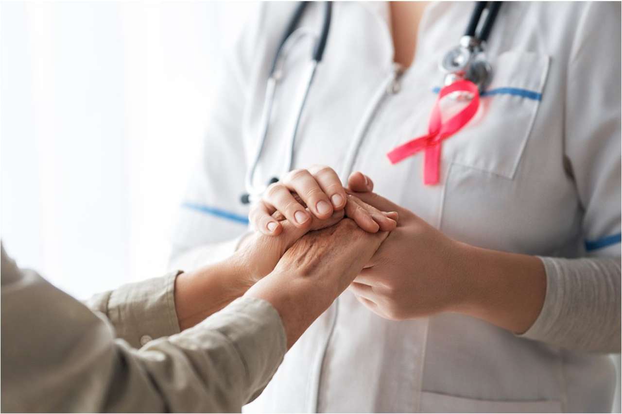 Female physician holds the hand of a breast cancer patient