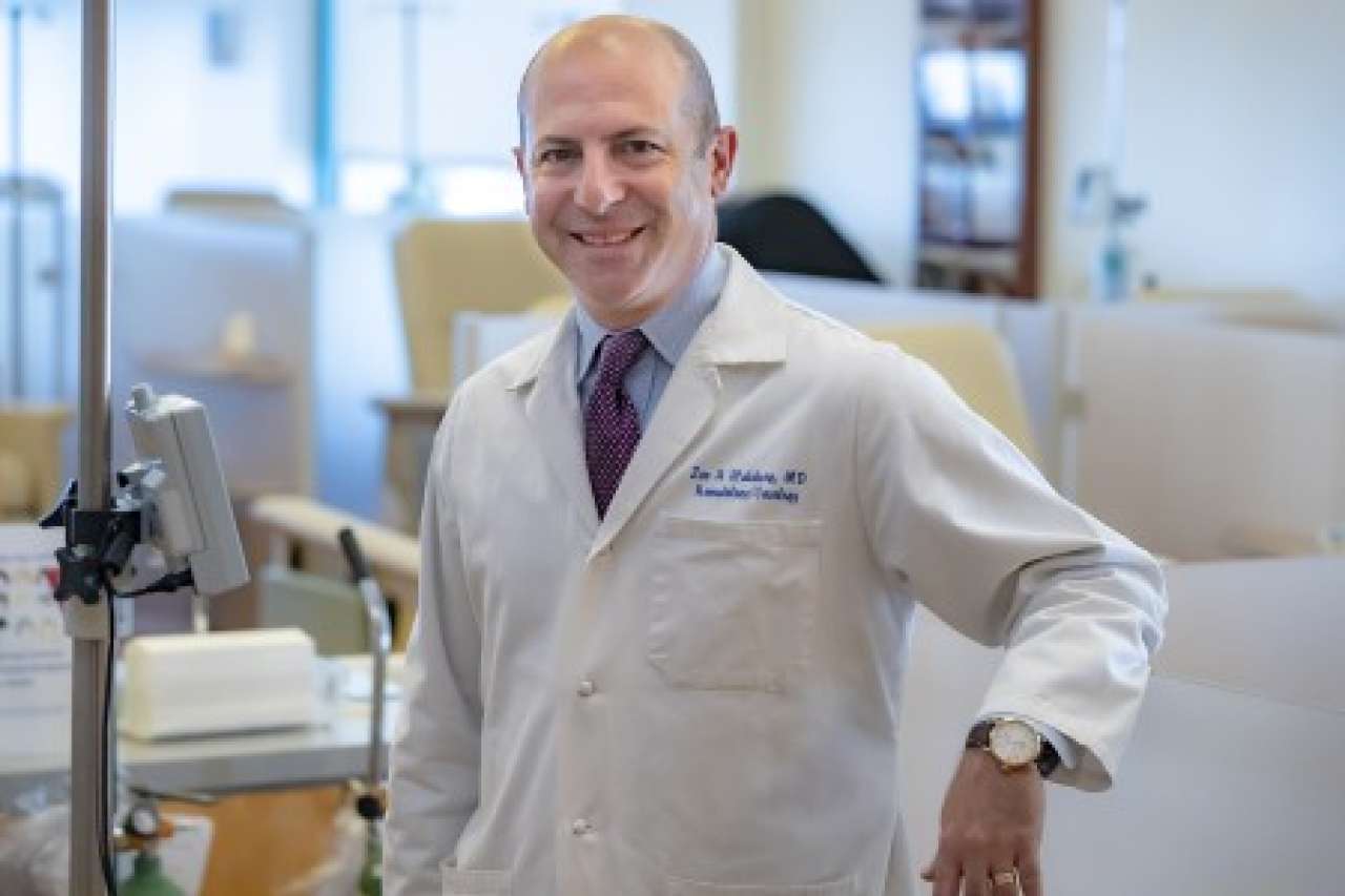 Doctor in a lab coat standing in a medical facility.