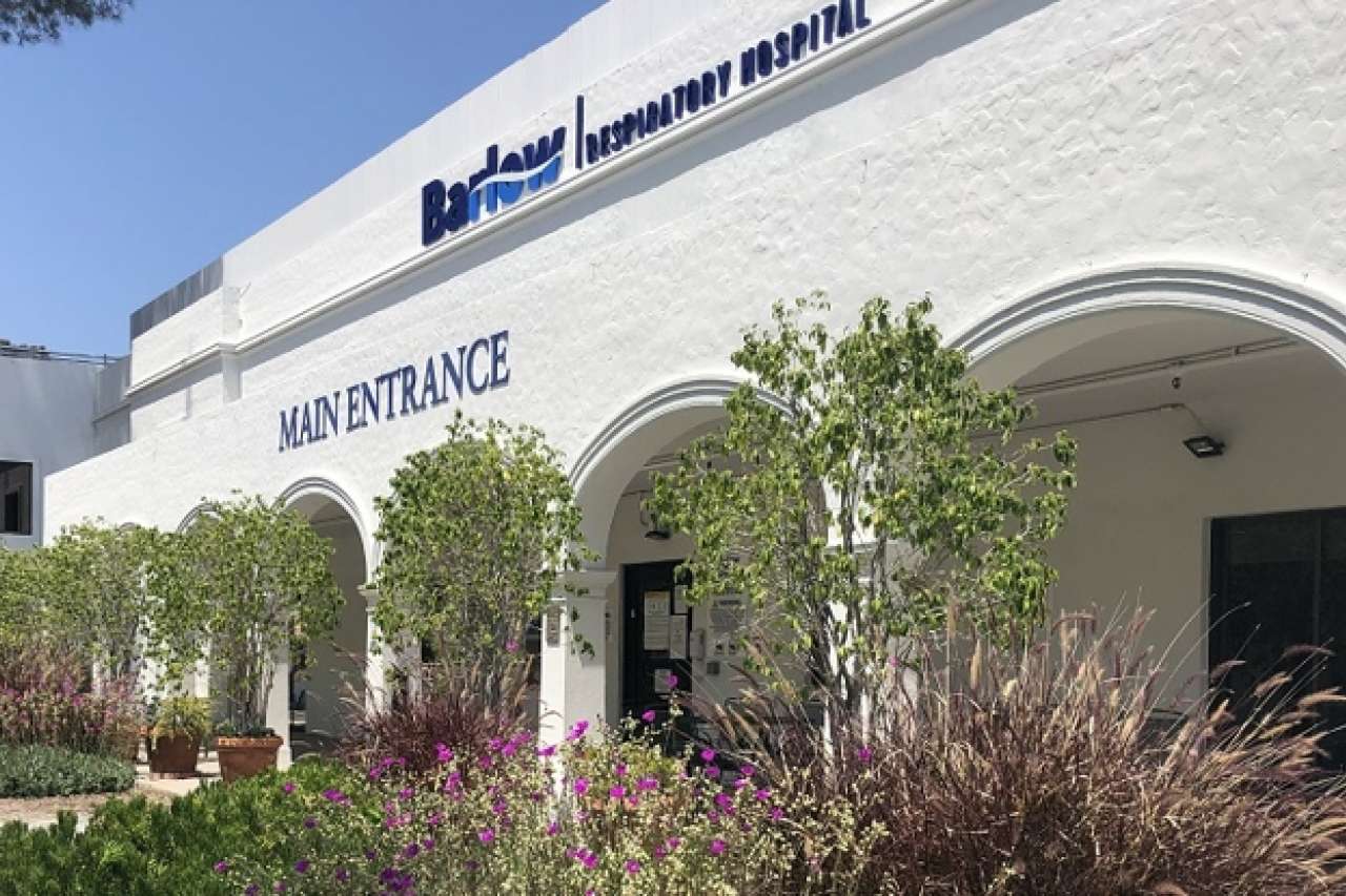 exterior of the Barlow hospital with pillars and trees near the pillars