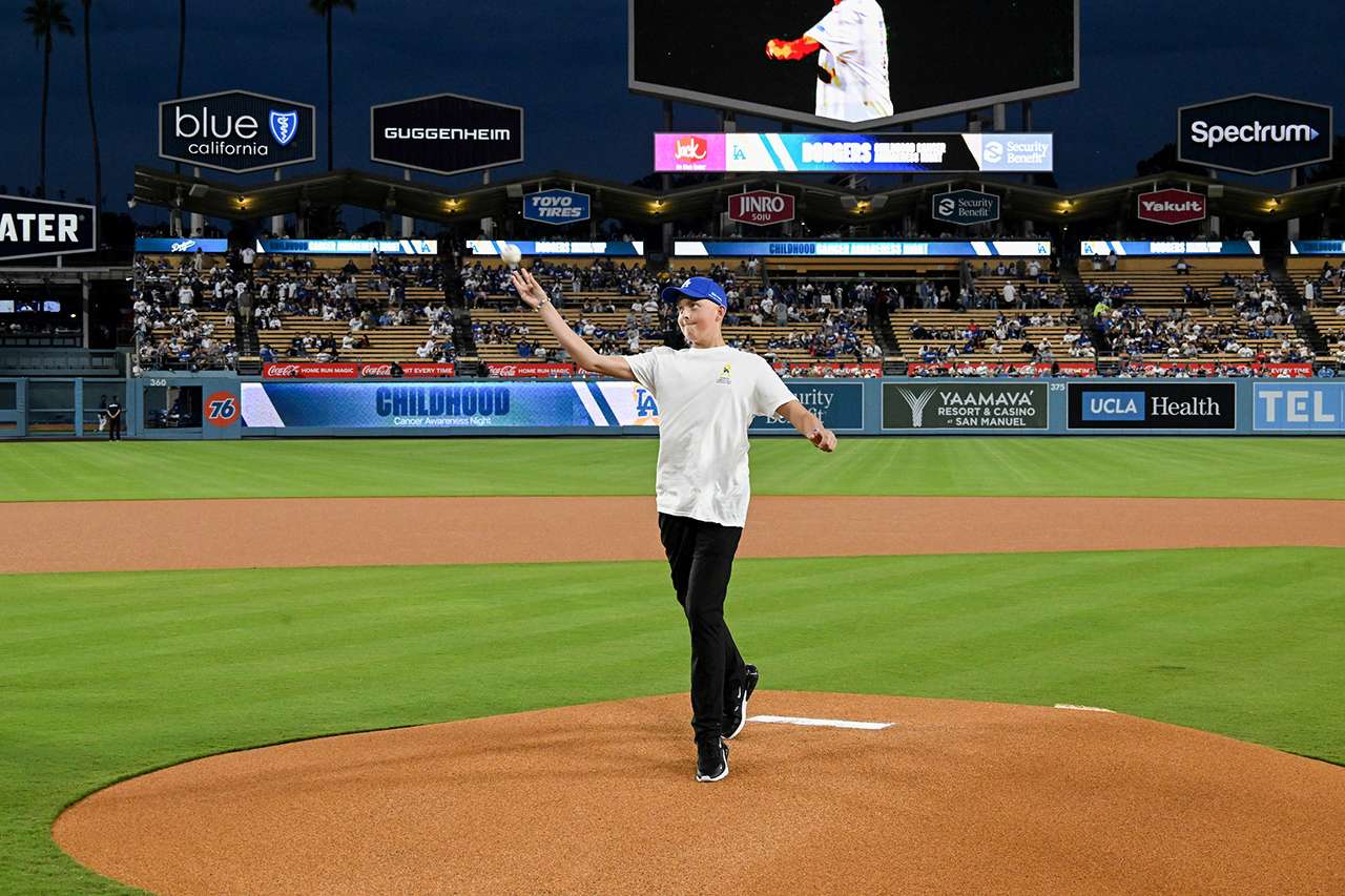 A young cancer patient throws at the first pitch at Dodger Stadium.