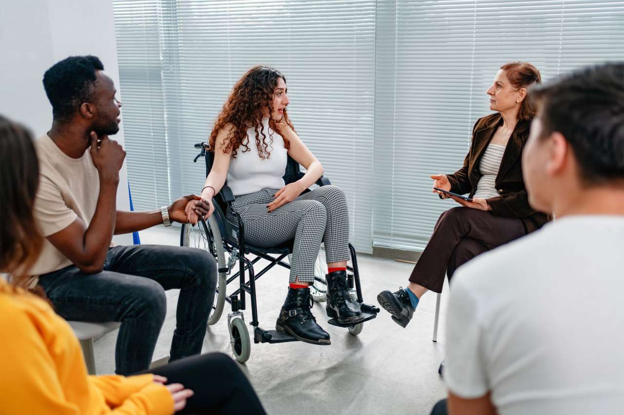 several people sitting in a Support group gathering for a meeting.