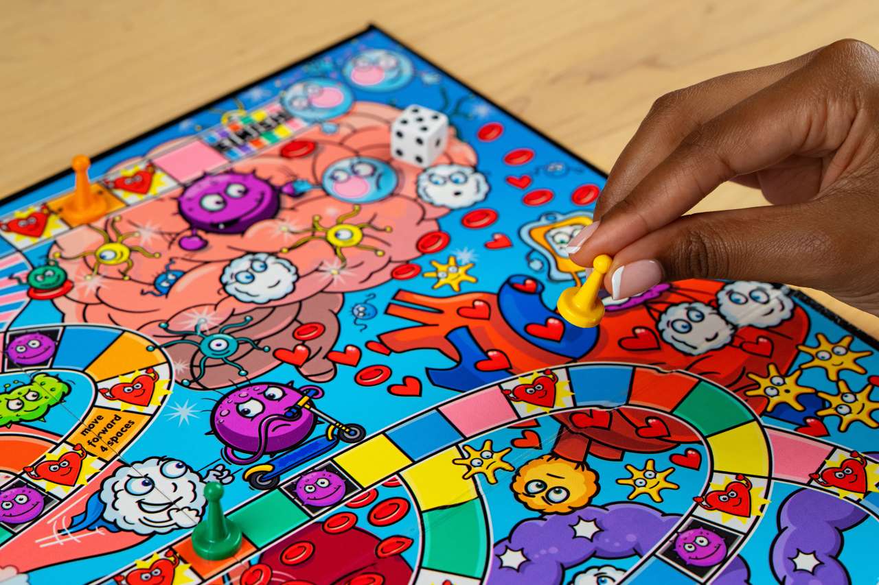The Cancer Crusher board game has vibrant colors and illustrations.