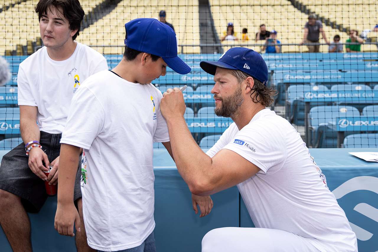 Clayton Kershaw signs an autograph for a young guest