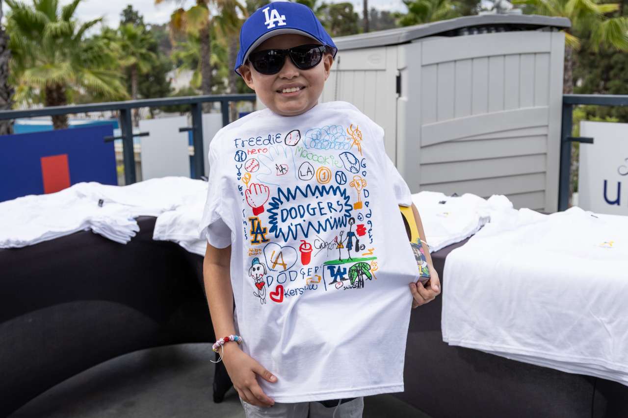 A boy shows off a colorful T-shirt with player names on it that the children created.