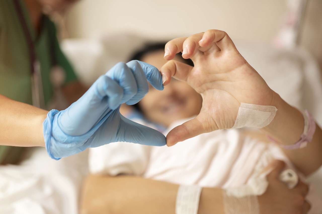Doctor and a patient putting their hands together to form a heart