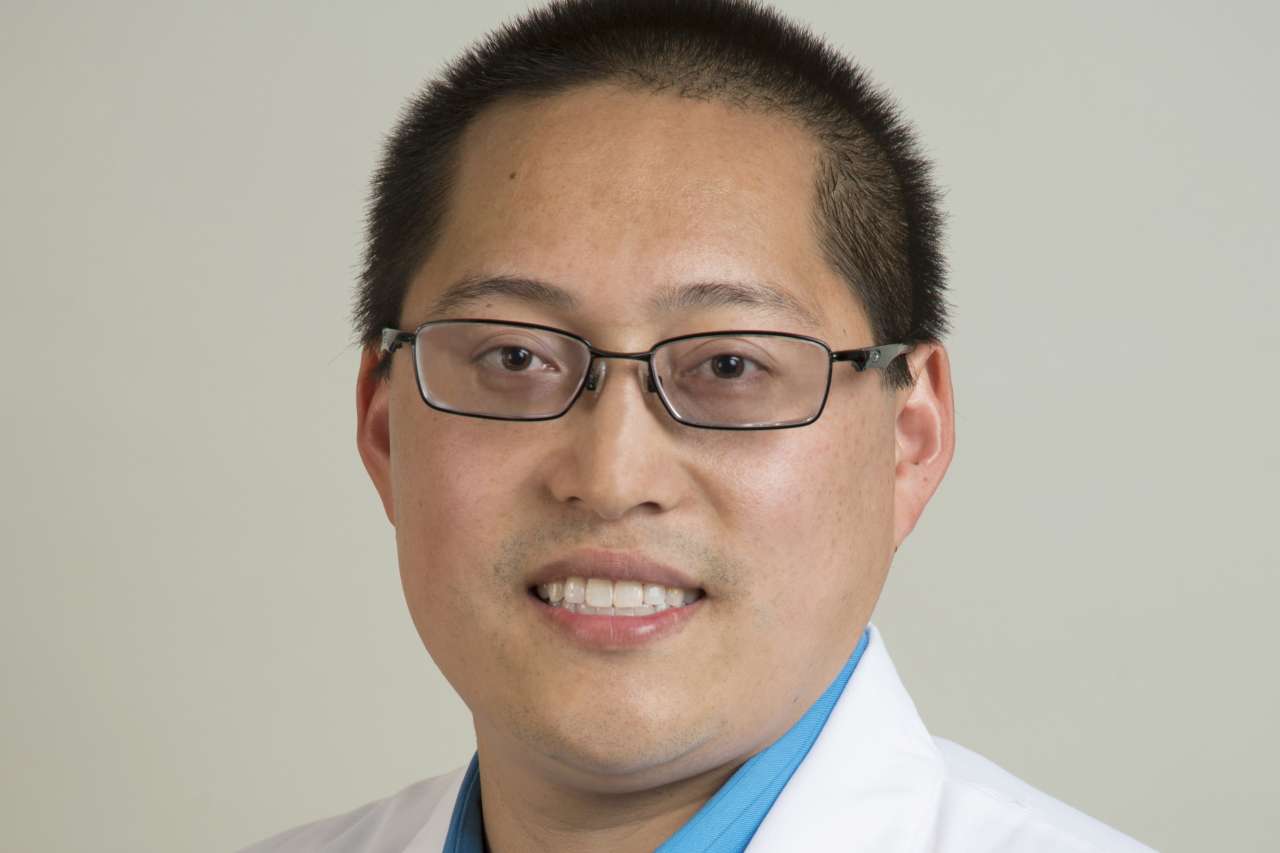 Person in white coat and glasses, professional headshot