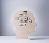 Wooden human head silhouette with nine small square drawers arranged like a brain