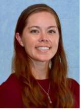 Head-and-shoulders portrait of person with long brown hair, face blurred, red top, necklace