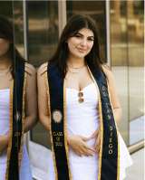 Melody Sagarian, who has brown hair, wearing a white dress and blue graduation stole.