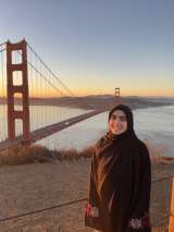 Photo of Howra posing in front of a bridge during sunset