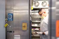 At the components processing lab, a technician unpacks and stores the donor’s unit of blood in a refrigerator